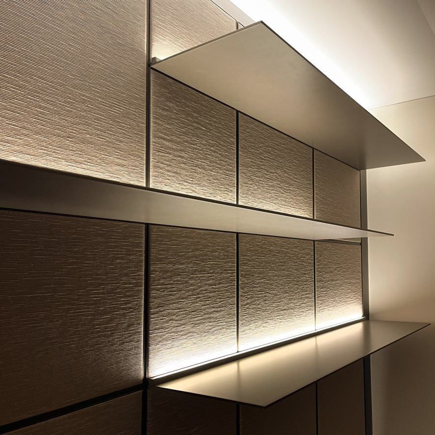 Bronze-panelled niche with recessed illuminated shelves and finely grained surfaces