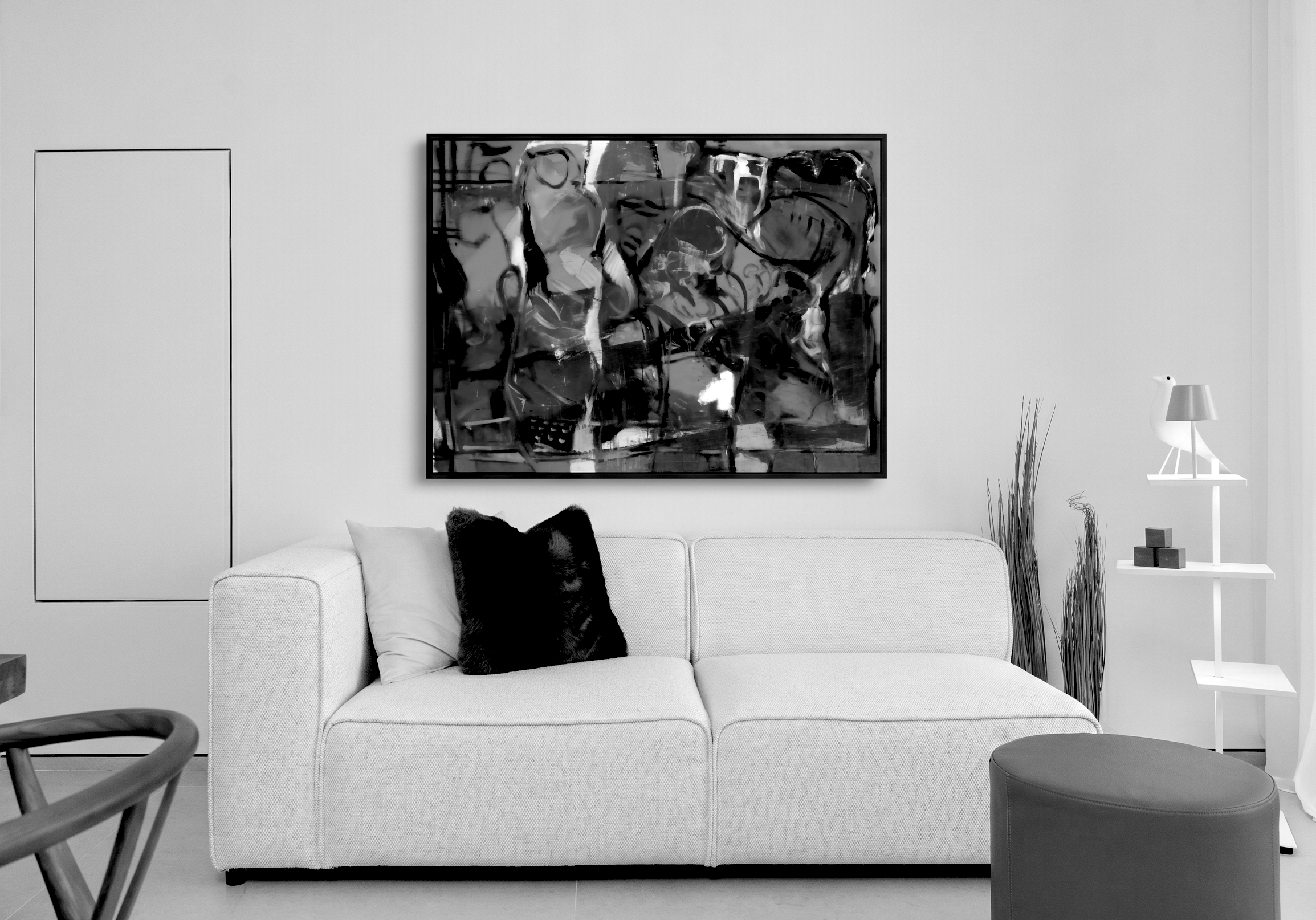 Black-and-white interior at Address Beach Resort featuring an abstract painting by Emmanuel Guiragossian above a white sofa.