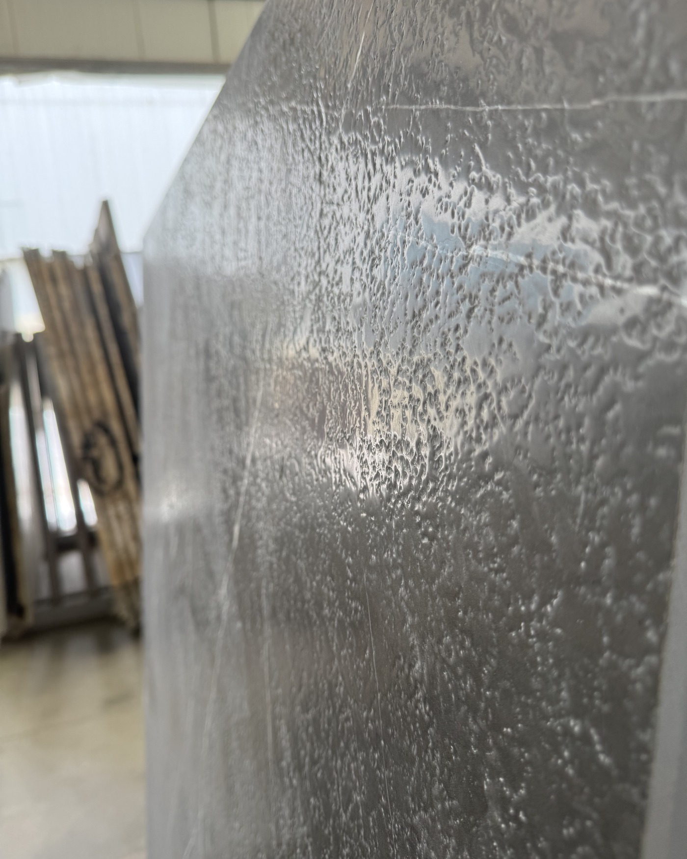 Close detail of a leathered marble slab with softly textured surface and fine veining.